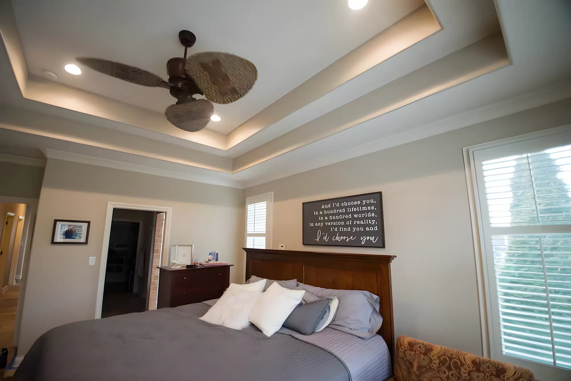 A bedroom with a painted tray ceiling and walls