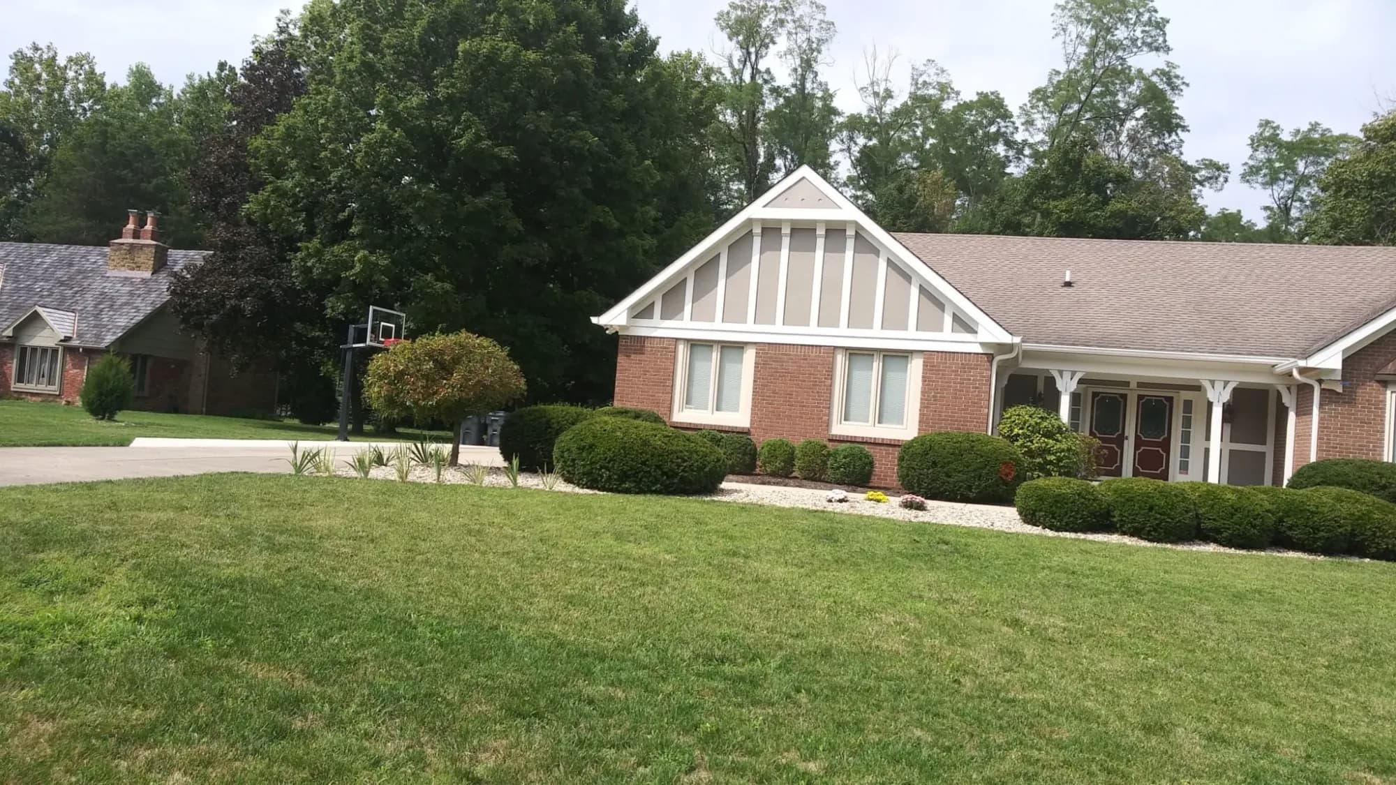 A two-story home with freshly painted siding and trim by ALL IN Painting
